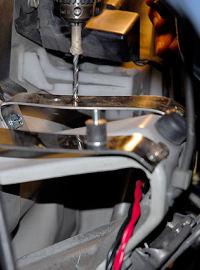 トゥボードに純正で取り付けられたステーに自作のステーと防振ゴムを取り付けて、取り付け穴を開ける