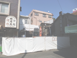 防音シートで囲われ、パワーショベルで解体されるおもちゃの店すぎやま。建物に看板が残る焼肉屋「名月苑」も2013年5月で閉店し、廃業しました。この焼肉屋はたくさんのファンを持つ地元の名店でした。オーナーがまた小さくても焼肉屋をはじめてくれるのを地元住民は心待ちしているようです。